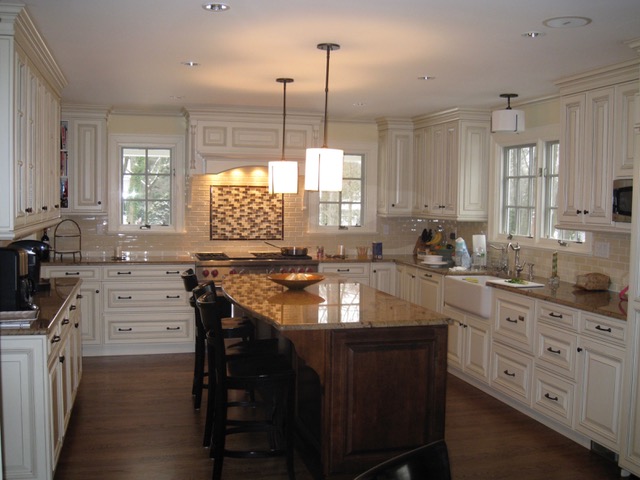 Designs by Dolores - White kitchen with dark wood floors and designed tile for stove backsplash