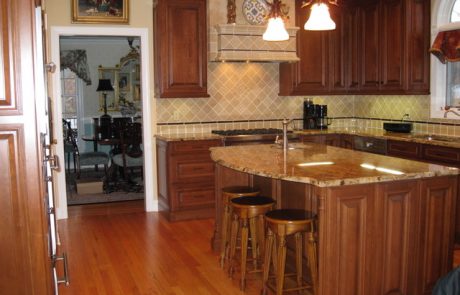 Designs by Dolores - Granite counters with wood floors and dark cabinets