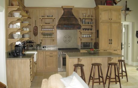 Designs by Dolores - Natural finish cabinets with unique rustic stove vent