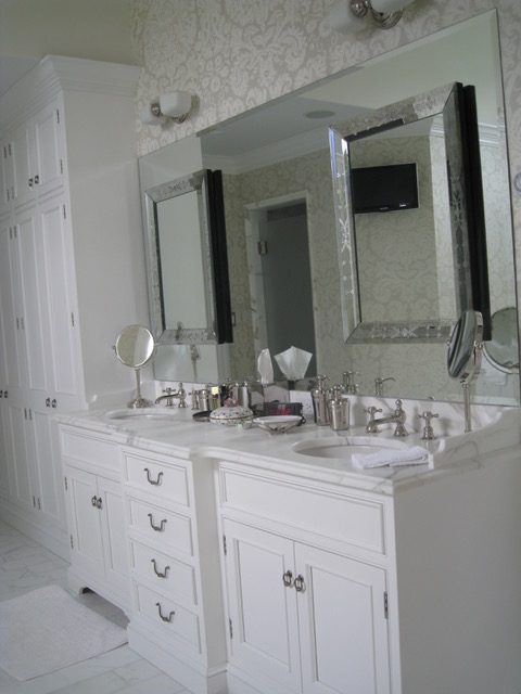Designs by Dolores - White bathroom cabinets with white counters and luxury wallpaper