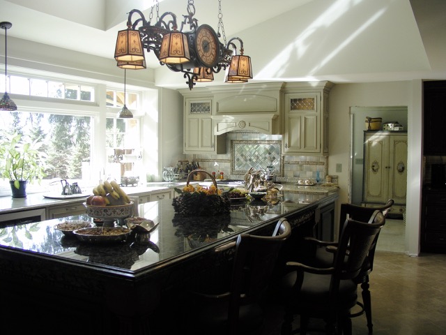 Designs by Dolores - Large island with dark cabinets matched with offwhite cabinetry