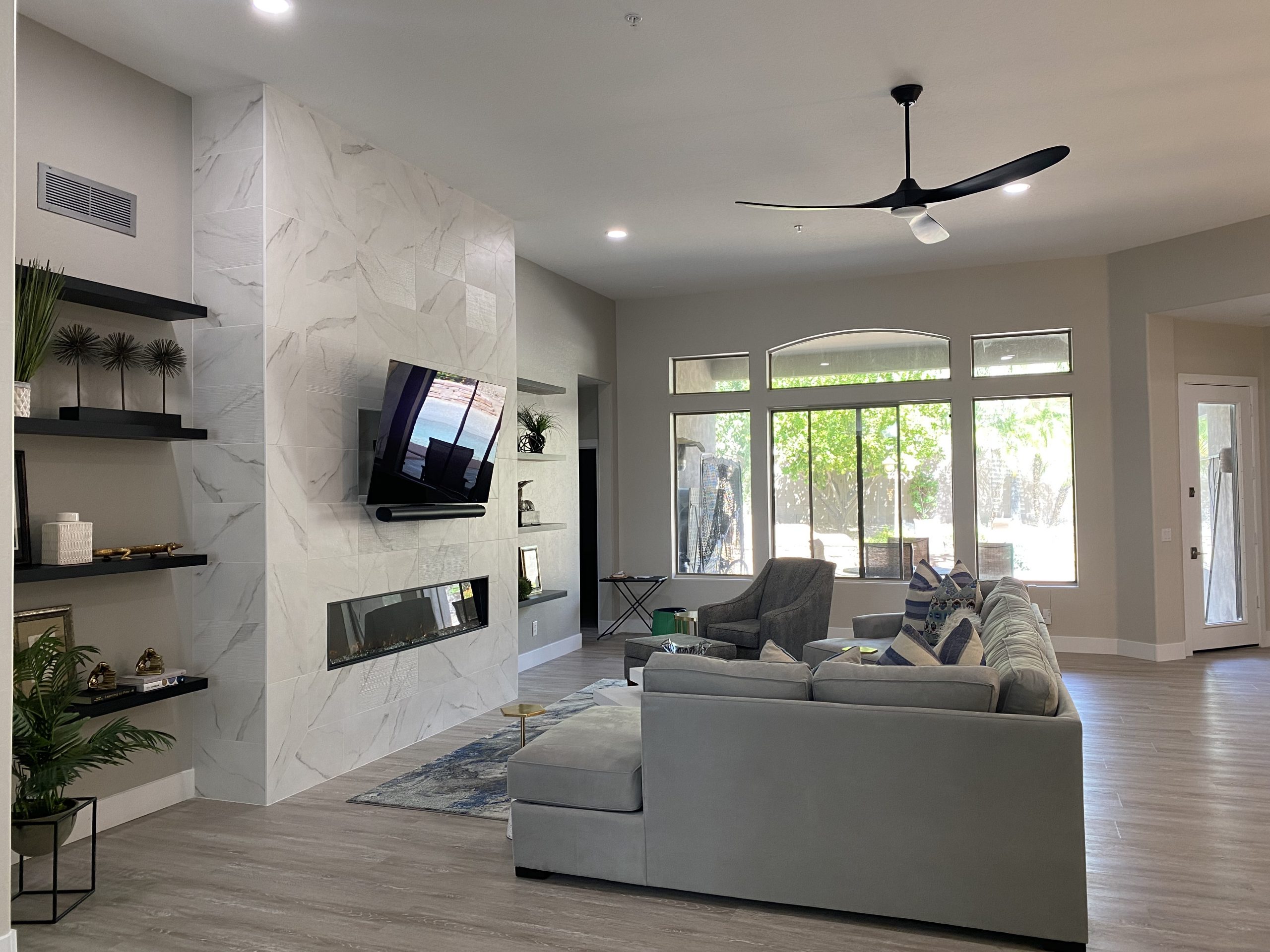 Modern living room renovation with grey accents, modern recessed fireplace and wall mounted tv.