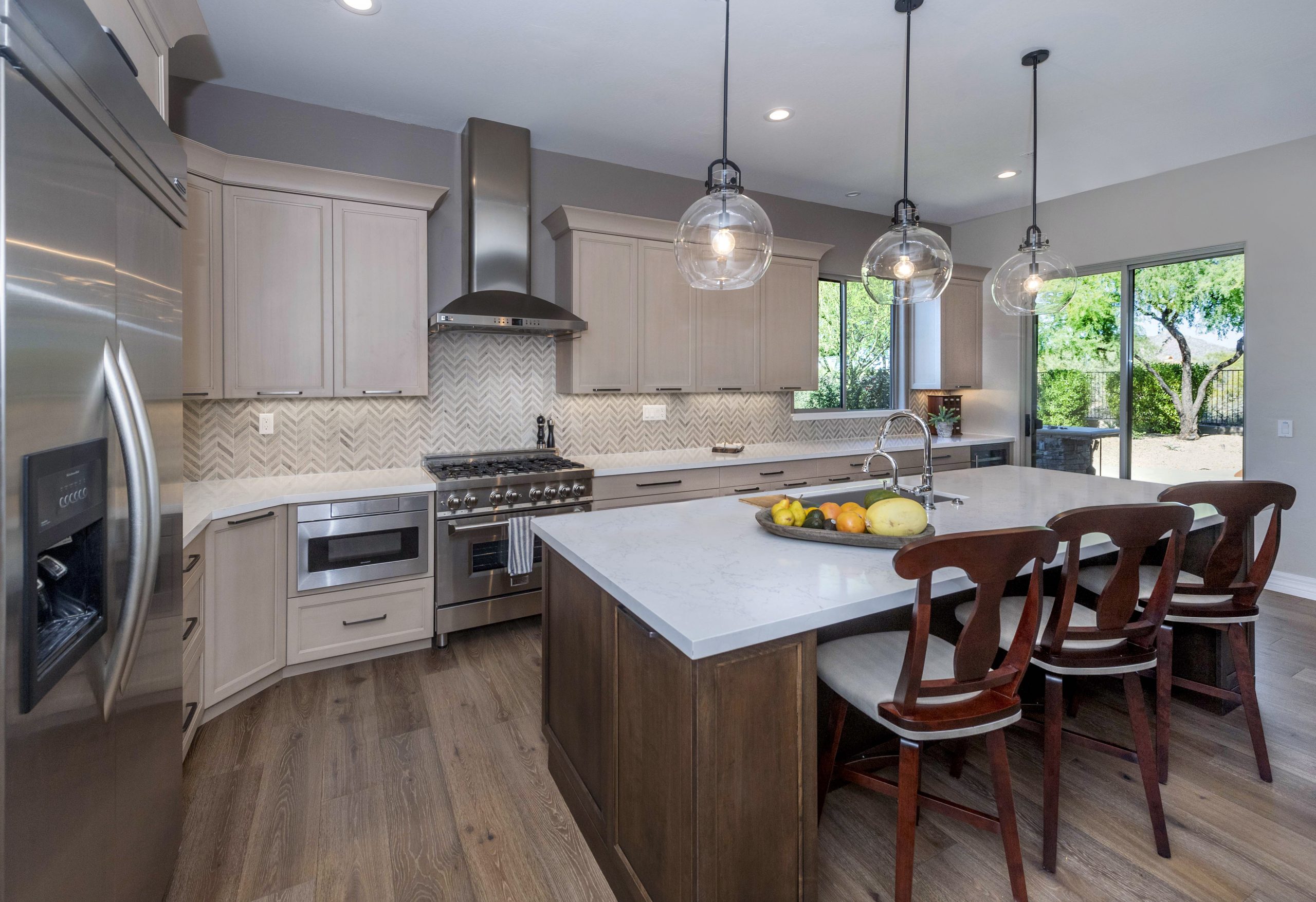 Kitchen redesign in Scottsdale with stainless appliances, light counters and dark island.